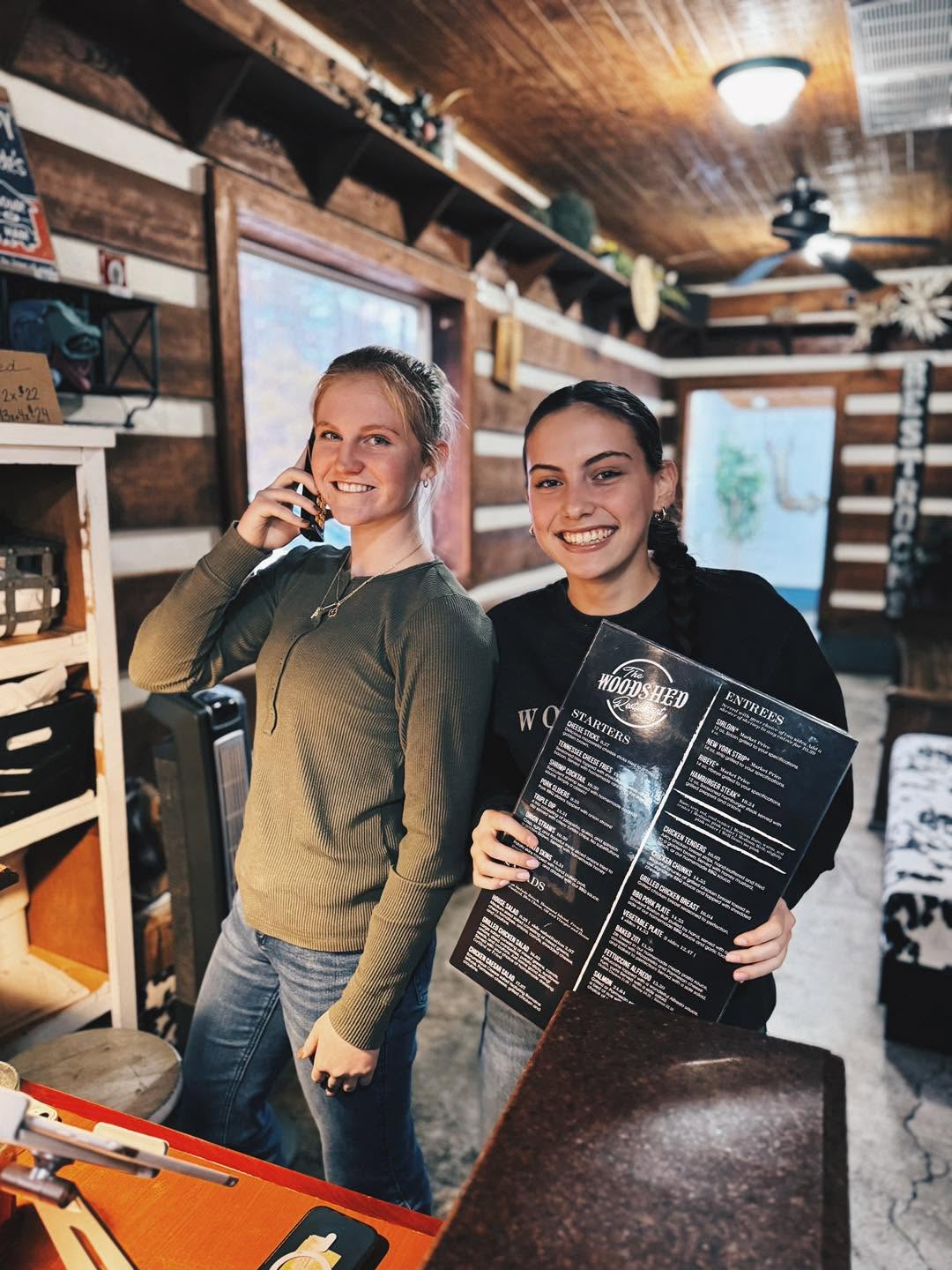 Woodshed staff members with a restaurant menu